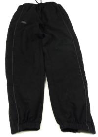 Černé šusťákové kalhoty s nápisem a logem zn. UMBRO