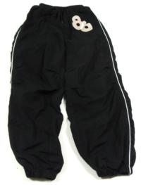 Černé šusťákové kalhoty s číslem zn. Cherokee 